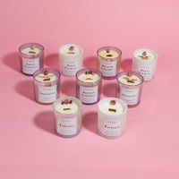 An assortment of our various floral collection offerings.  Includes both classic floral and Guns & Roses in 10oz wood wick.  The colors of the glasses range from iridescent pink to white, and the wax on all of the candles is white.