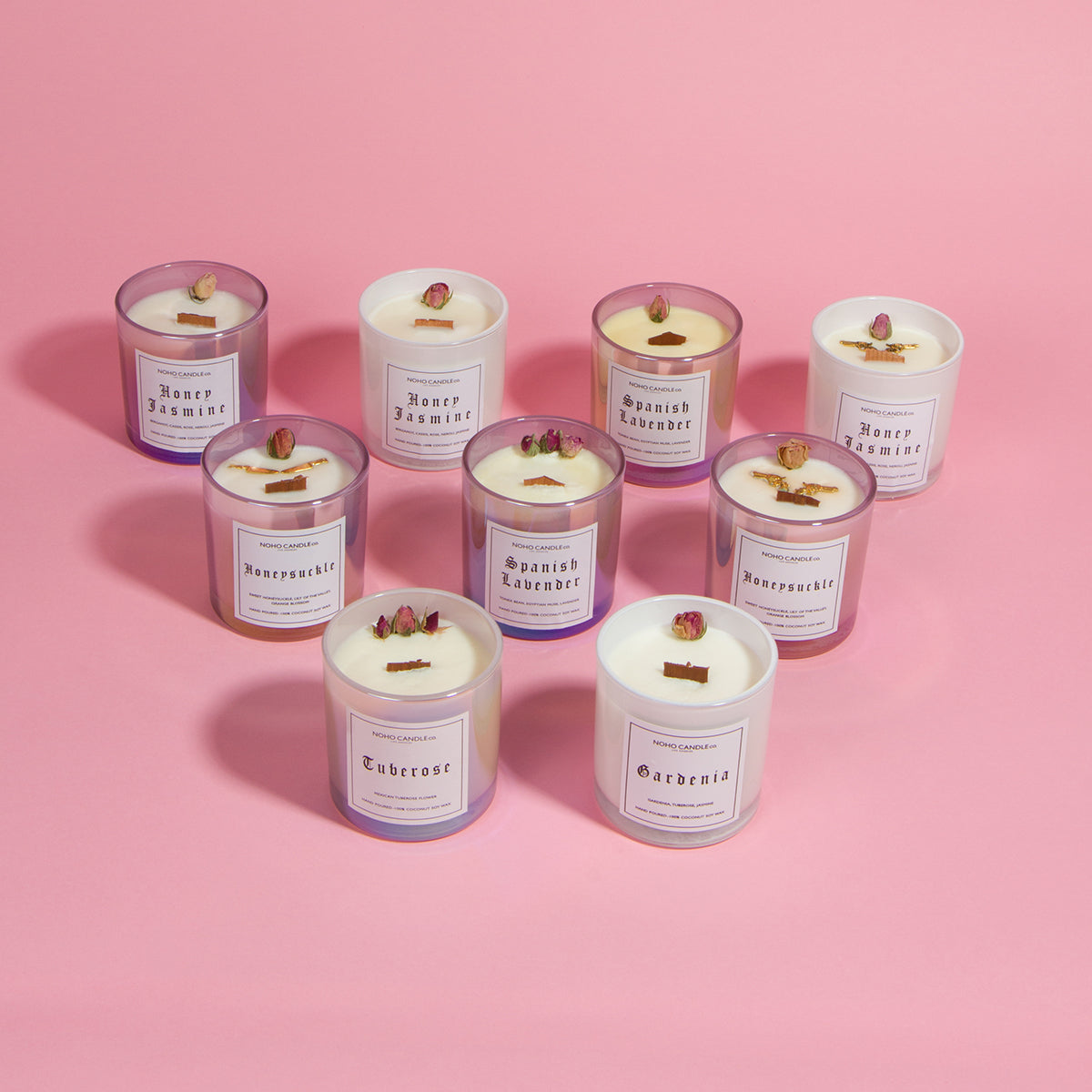 An assortment of our various floral collection offerings.  Includes both classic floral and Guns & Roses in 10oz wood wick.  The colors of the glasses range from iridescent pink to white, and the wax on all of the candles is white.