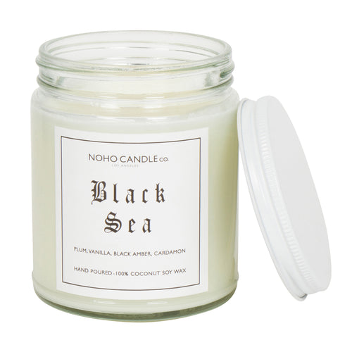 An 8oz short Black Sea candle.  The jar is clear and the candle is white. The lid to the jar is white and screws on.