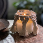 A Macrame candle cover.  It's off-white and braided.  Slightly darker than the candles when the candle's lit, but when the candle's unlit, the color looks lighter..