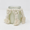 Unlit candle jar with a macrame cover. 