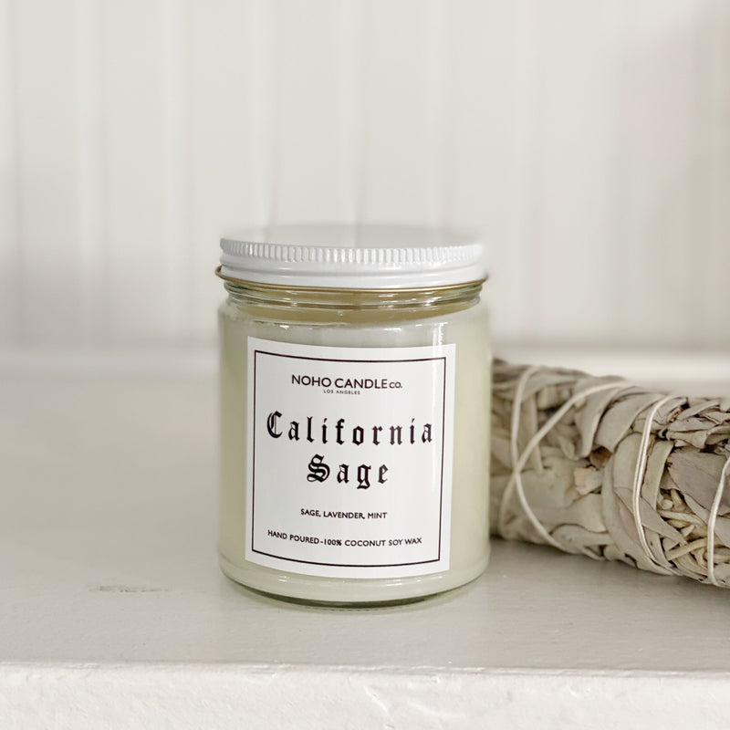 A California Sage candle next to a bundle of sage.
