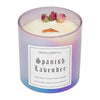 A 10oz Spanish Lavender Floral Collection candle with a wood wick.  The wax is white and there are three dried, natural roses arranged near the edge.  The glass in the picture is iridescent purple and the candle comes with a clear plastic lid.