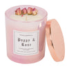 A 14oz cotton wick Poppy & Rose candle.  The wax is white and has four natural, dried roses arranged near the edge.  The glass is iridescent pink and the lid is copper and pops on and off.