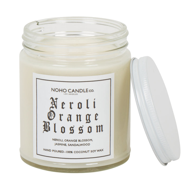 An 8oz short Neroli Orange Blossom candle.  The wax is white, the glass is clear, and the lid is white and screws on.