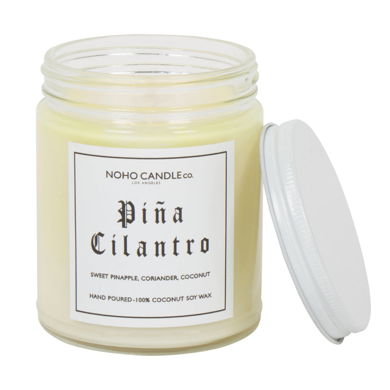 An 8oz short Pina Cilantro candle.  The wax is white with a subtle yellow tint, the jar is clear, and the lid is white and screws on.