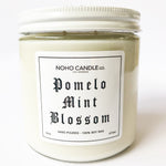 A 16-oz jar of Pomelo Mint Blossom candle with a white screw-on lid.